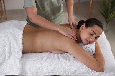 Photo of Young woman receiving massage in spa salon