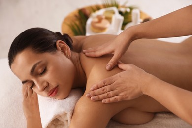 Photo of Young woman receiving massage in spa salon