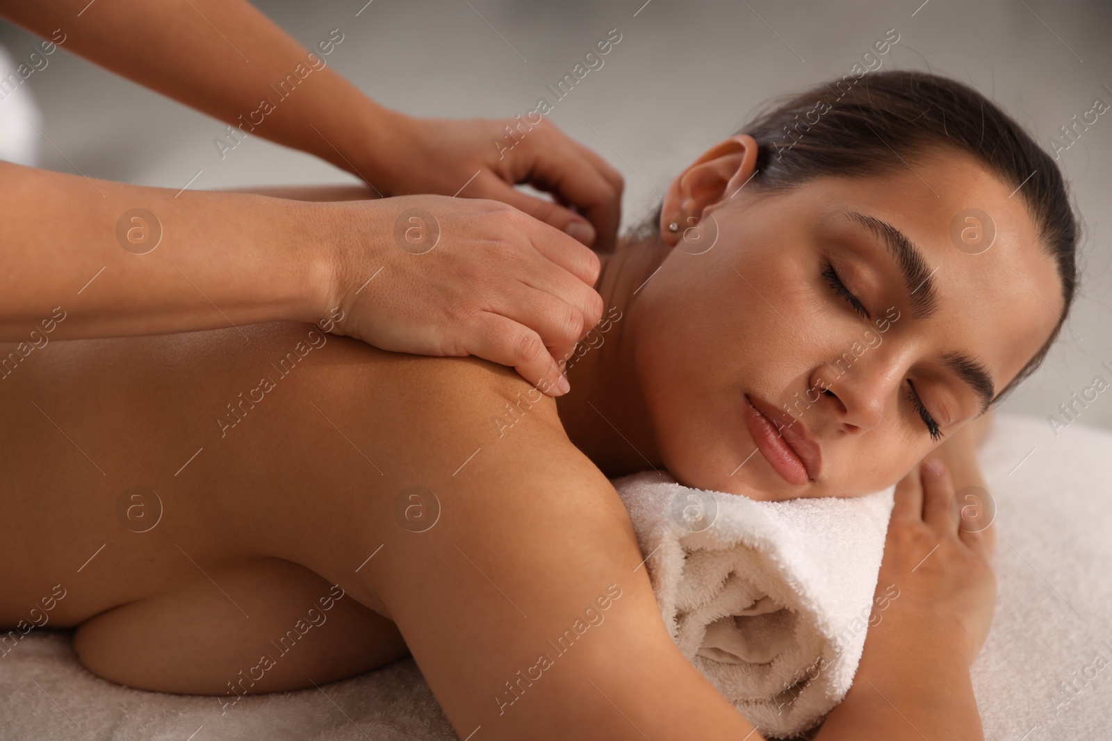 Photo of Young woman receiving massage in spa salon