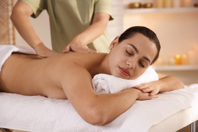 Photo of Young woman receiving massage in spa salon