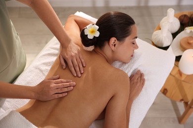 Photo of Woman receiving back massage in spa salon, top view