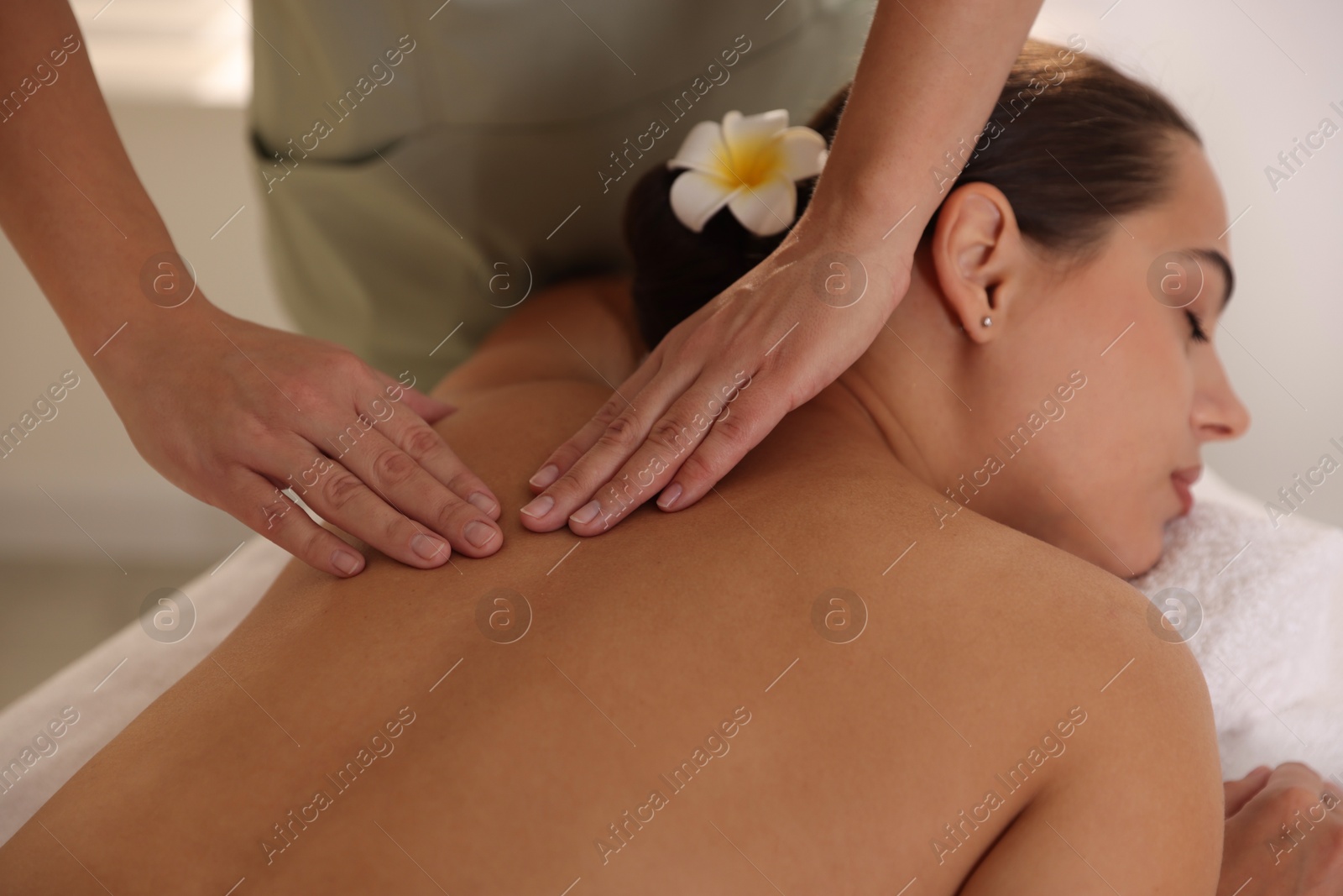 Photo of Woman receiving back massage in spa salon