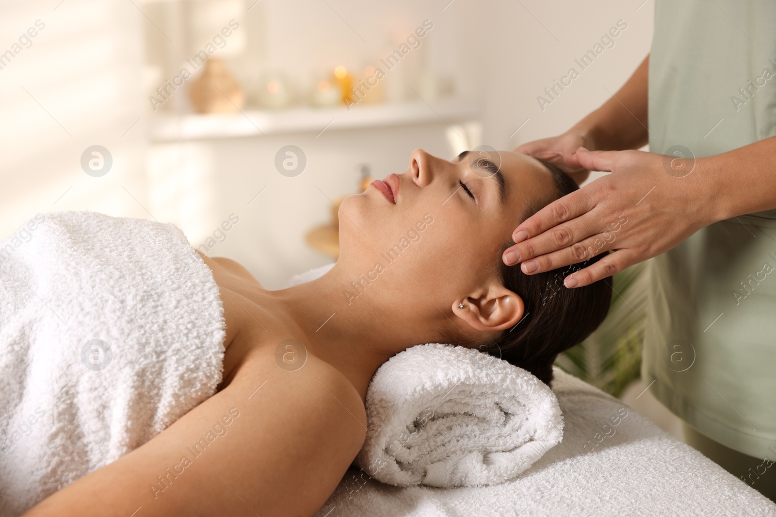 Photo of Young woman receiving massage in spa salon