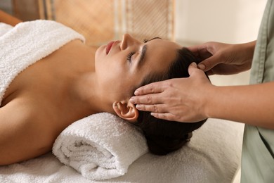 Photo of Young woman receiving massage in spa salon