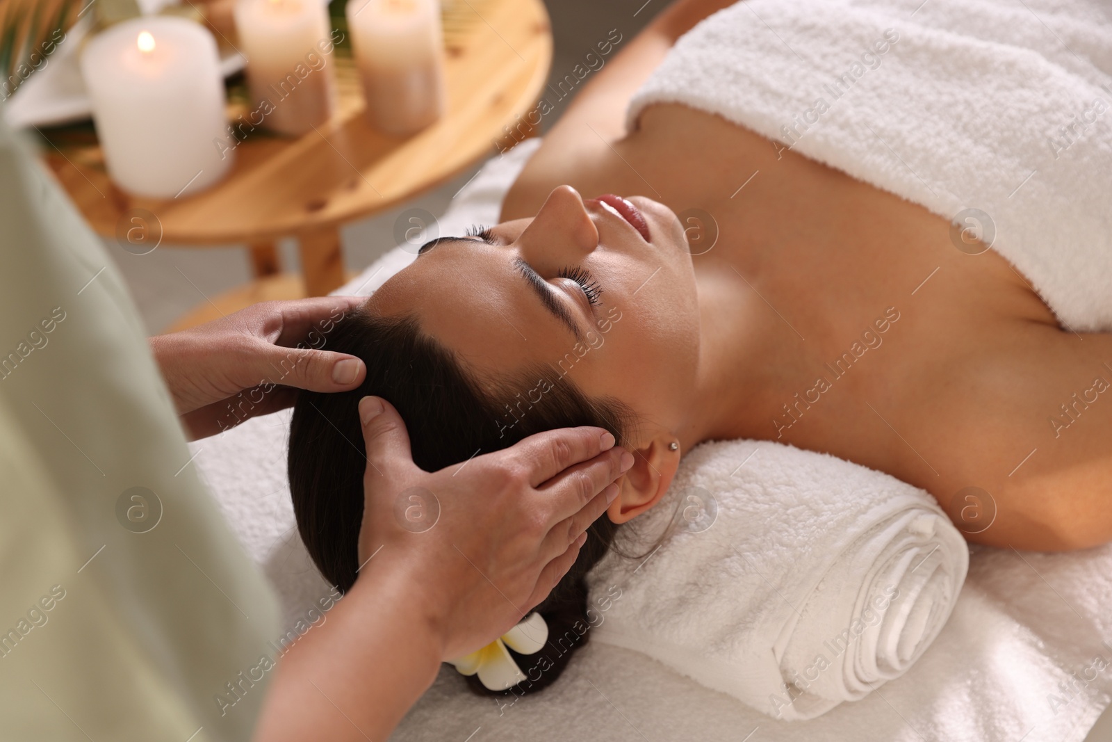 Photo of Young woman receiving massage in spa salon