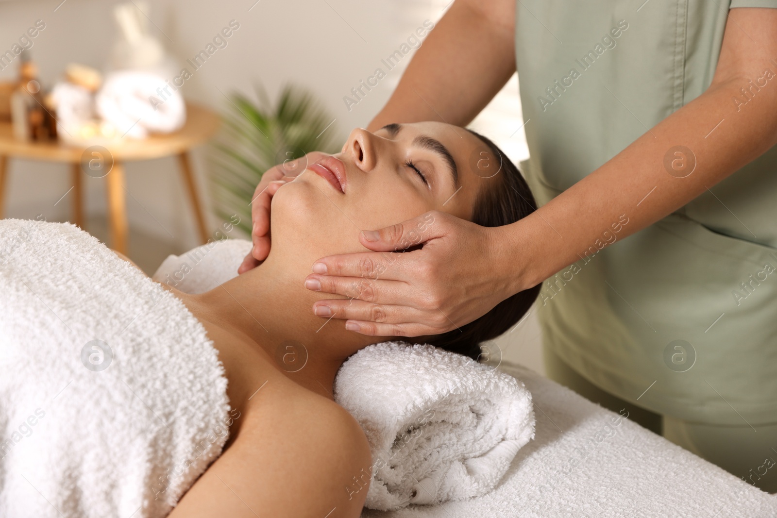 Photo of Young woman receiving massage in spa salon