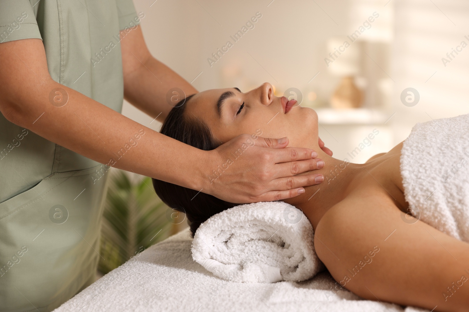 Photo of Young woman receiving massage in spa salon