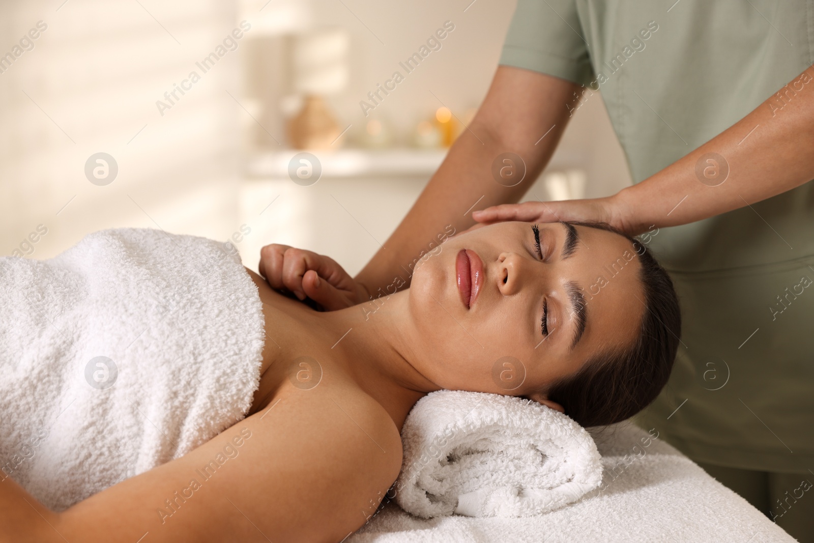 Photo of Young woman receiving massage in spa salon