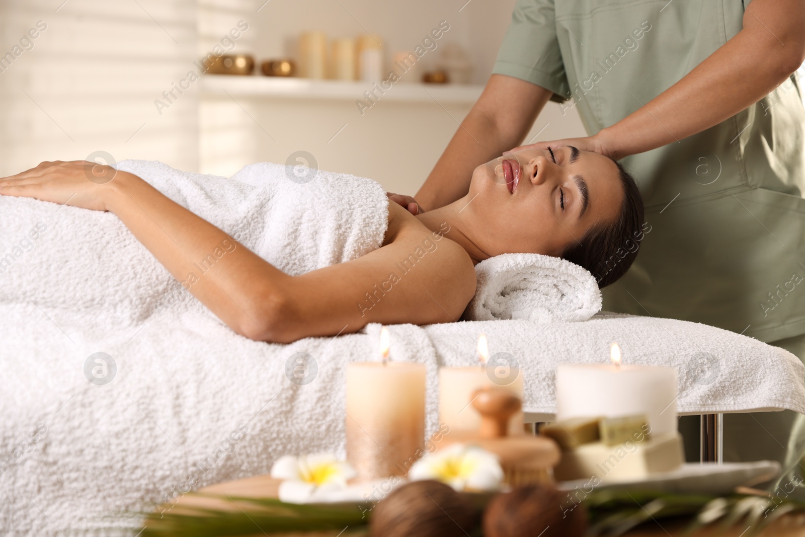 Photo of Young woman receiving massage in spa salon