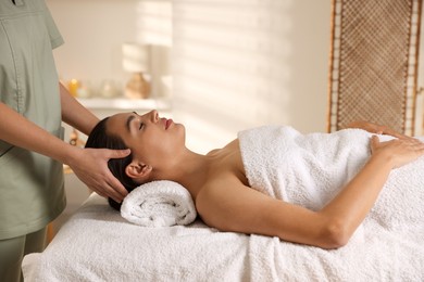 Photo of Young woman receiving massage in spa salon