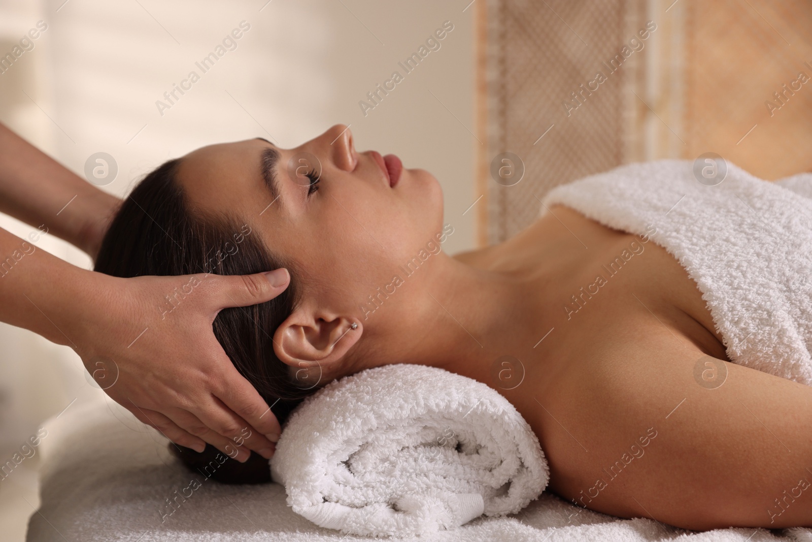 Photo of Young woman receiving massage in spa salon