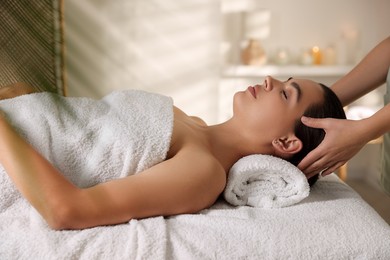 Photo of Young woman receiving massage in spa salon