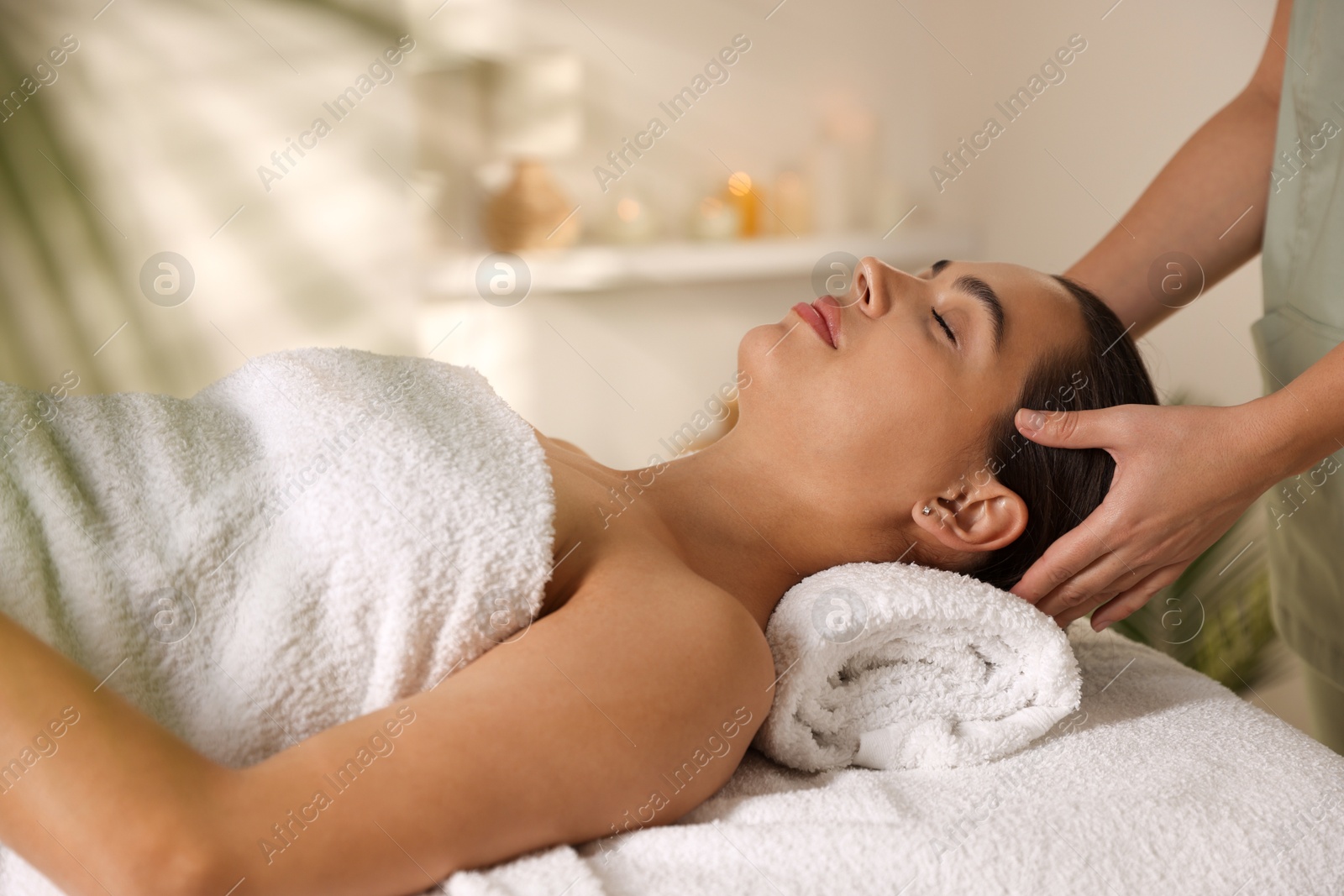 Photo of Young woman receiving massage in spa salon