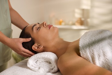 Photo of Young woman receiving massage in spa salon