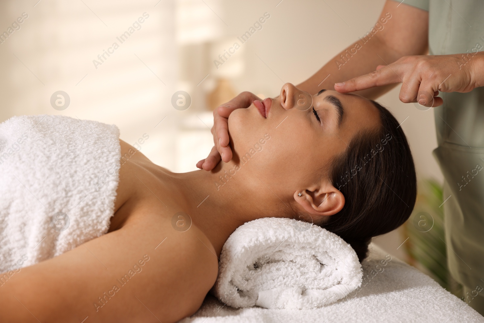 Photo of Woman receiving face massage in spa salon