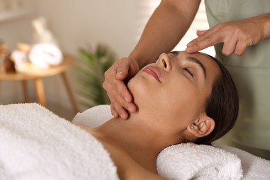 Photo of Woman receiving face massage in spa salon