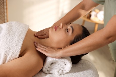 Photo of Young woman receiving massage in spa salon