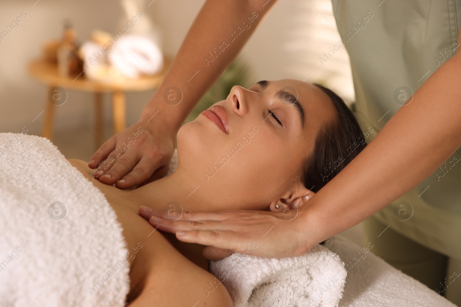 Photo of Young woman receiving massage in spa salon