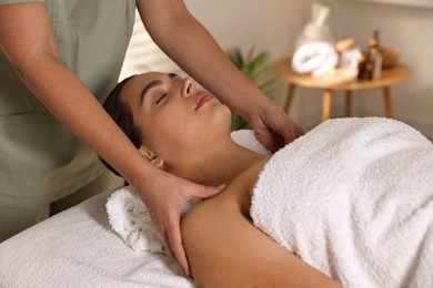 Photo of Young woman receiving massage in spa salon