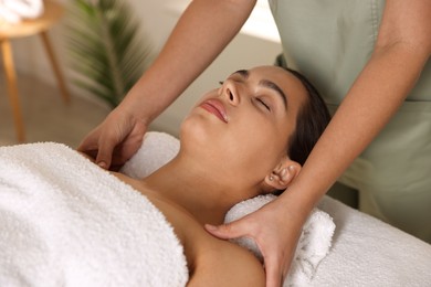 Photo of Young woman receiving massage in spa salon