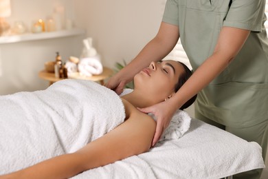 Photo of Young woman receiving massage in spa salon