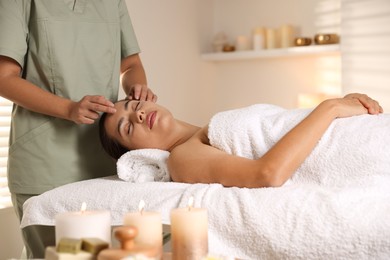 Woman receiving face massage in spa salon