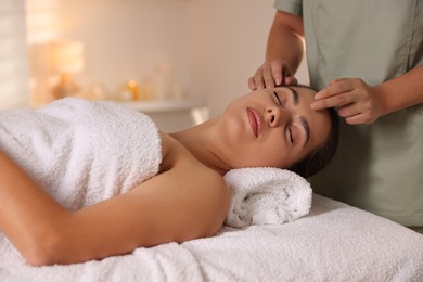 Photo of Woman receiving face massage in spa salon