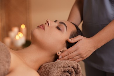 Photo of Young woman receiving massage in spa salon