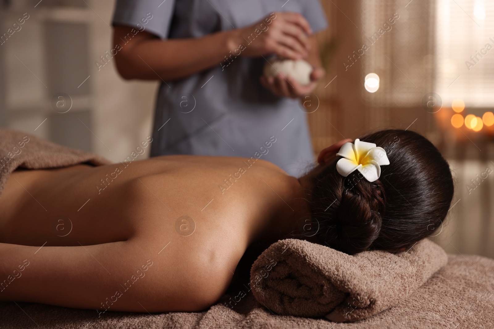 Photo of Woman lying on massage table in spa salon