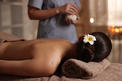 Woman lying on massage table in spa salon