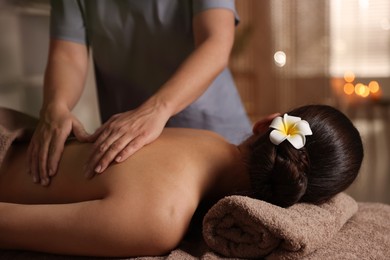 Photo of Woman receiving back massage in spa salon