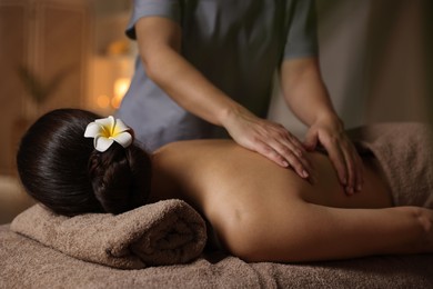 Photo of Woman receiving back massage in spa salon