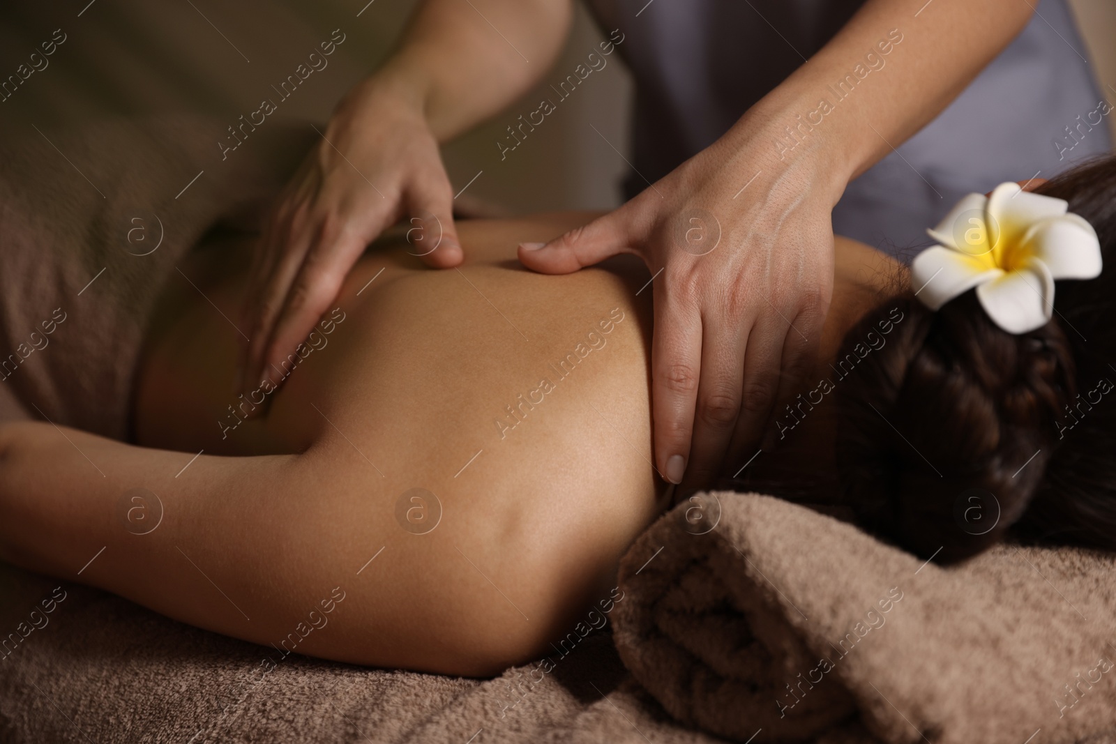 Photo of Woman receiving back massage in spa salon, closeup