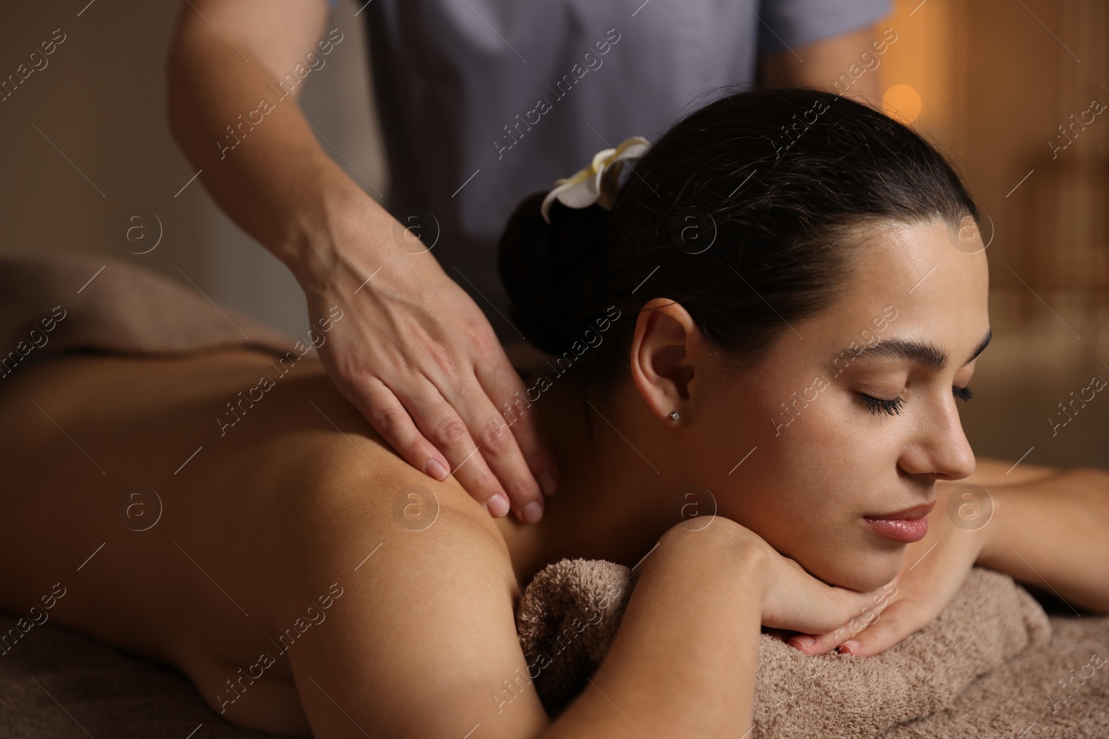 Photo of Woman receiving back massage in spa salon