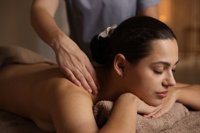 Photo of Woman receiving back massage in spa salon