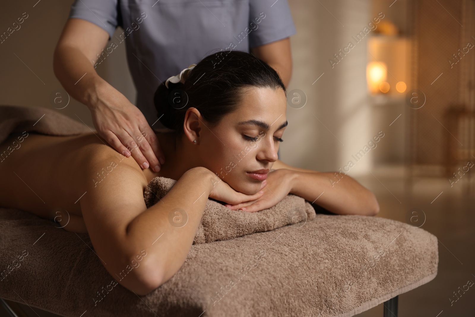 Photo of Woman receiving back massage in spa salon