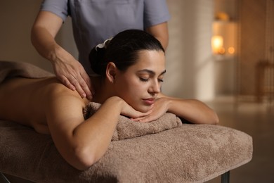 Woman receiving back massage in spa salon