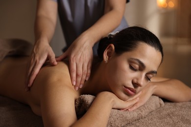 Woman receiving back massage in spa salon