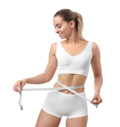 Photo of Weight loss. Happy woman measuring her slim waist with tape on white background