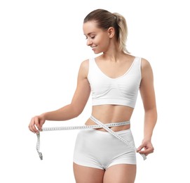 Weight loss. Happy woman measuring her slim waist with tape on white background