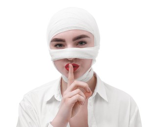 Photo of Woman with nose wrapped in medical bandage after plastic surgery operation making silent gesture on white background