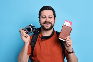 Traveller with vintage camera, passport and ticket on light blue background