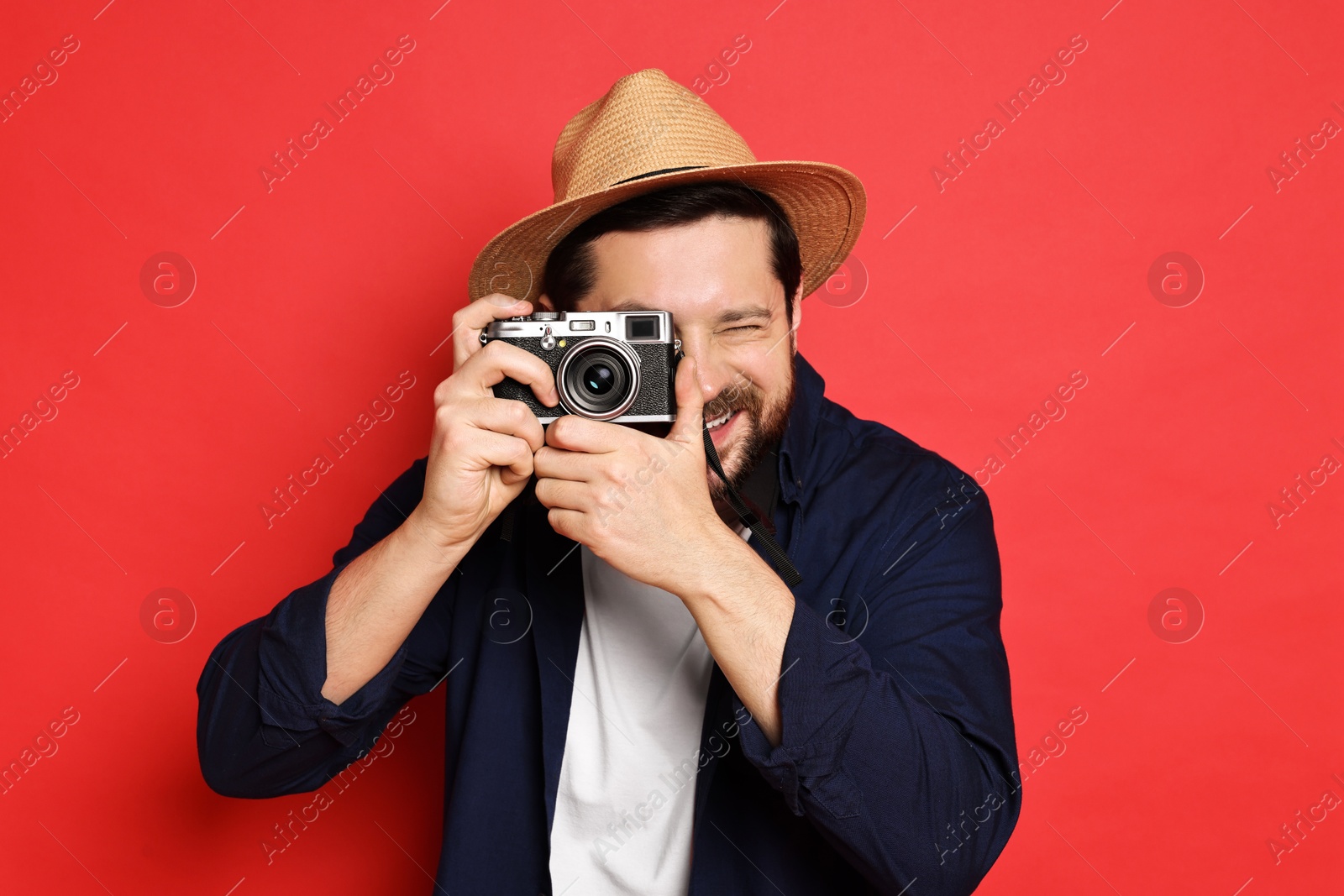 Photo of Traveller with vintage camera on red background