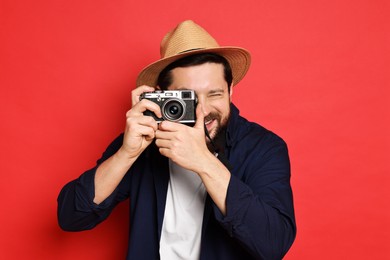 Traveller with vintage camera on red background