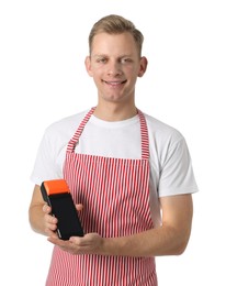 Happy young man in apron with payment terminal on white background