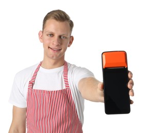 Happy young man in apron with payment terminal on white background