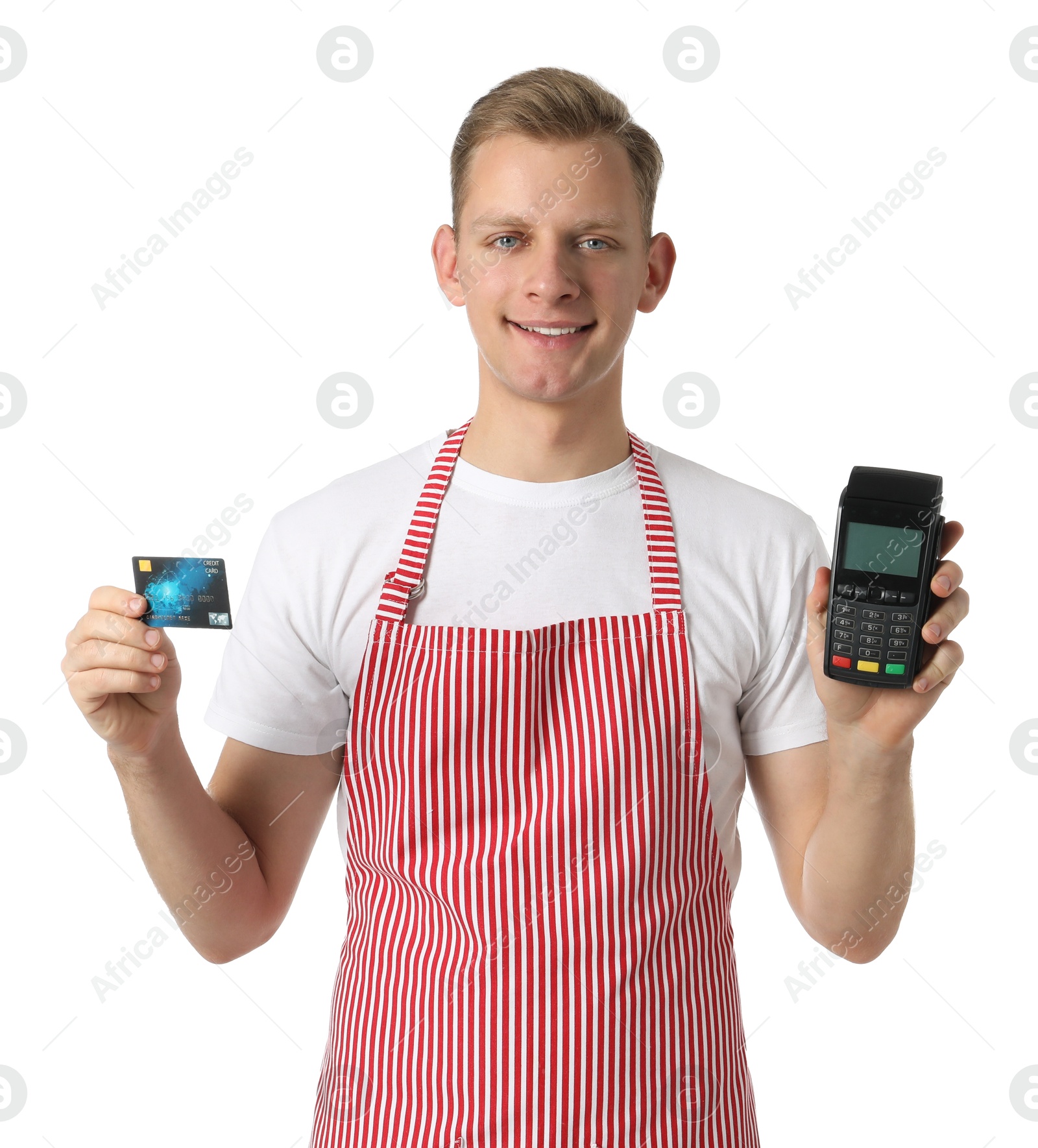 Photo of Happy young man in apron with payment terminal and debit card on white background