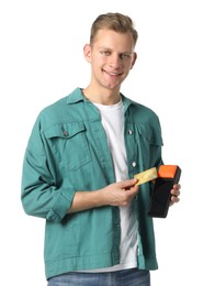 Happy young man with payment terminal and debit card on white background