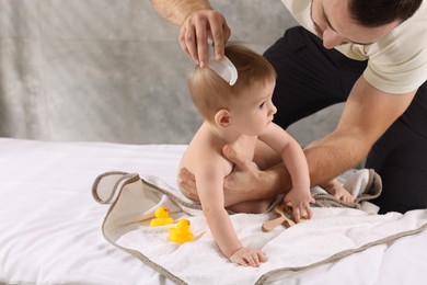 Photo of Man combing hair of his little baby indoors, space for text