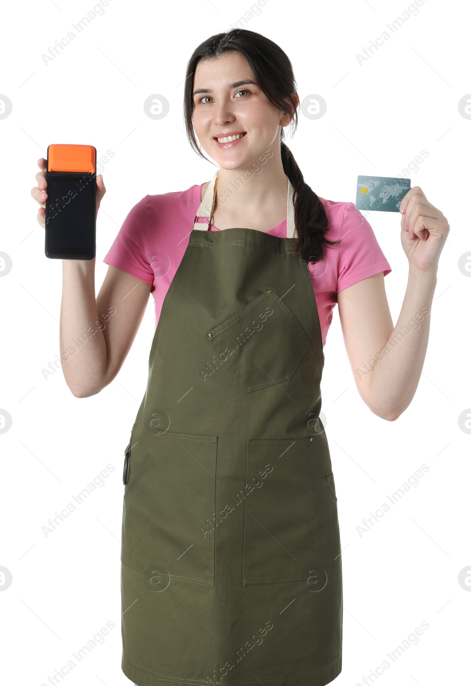 Photo of Happy young woman in apron with payment terminal and debit card on white background